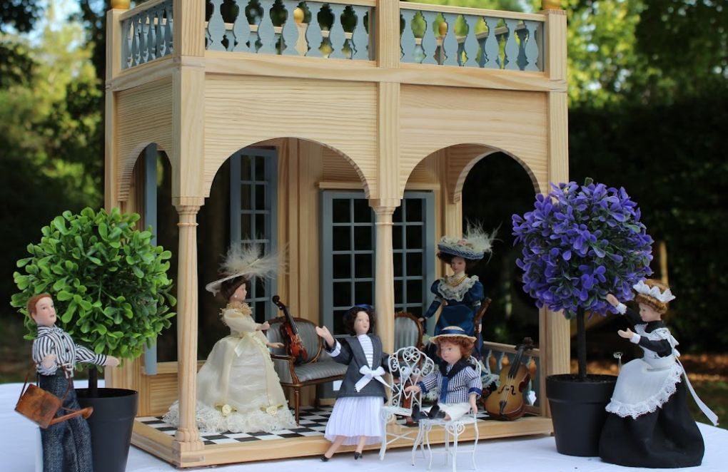 Figurines posées sur une maison de poupées en bois K'Tom
