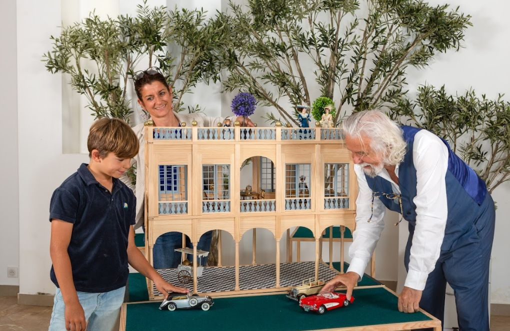 Tom Van Der Bruggen avec son petit fils et sa fille jouant avec une maison de poupée K'Tom